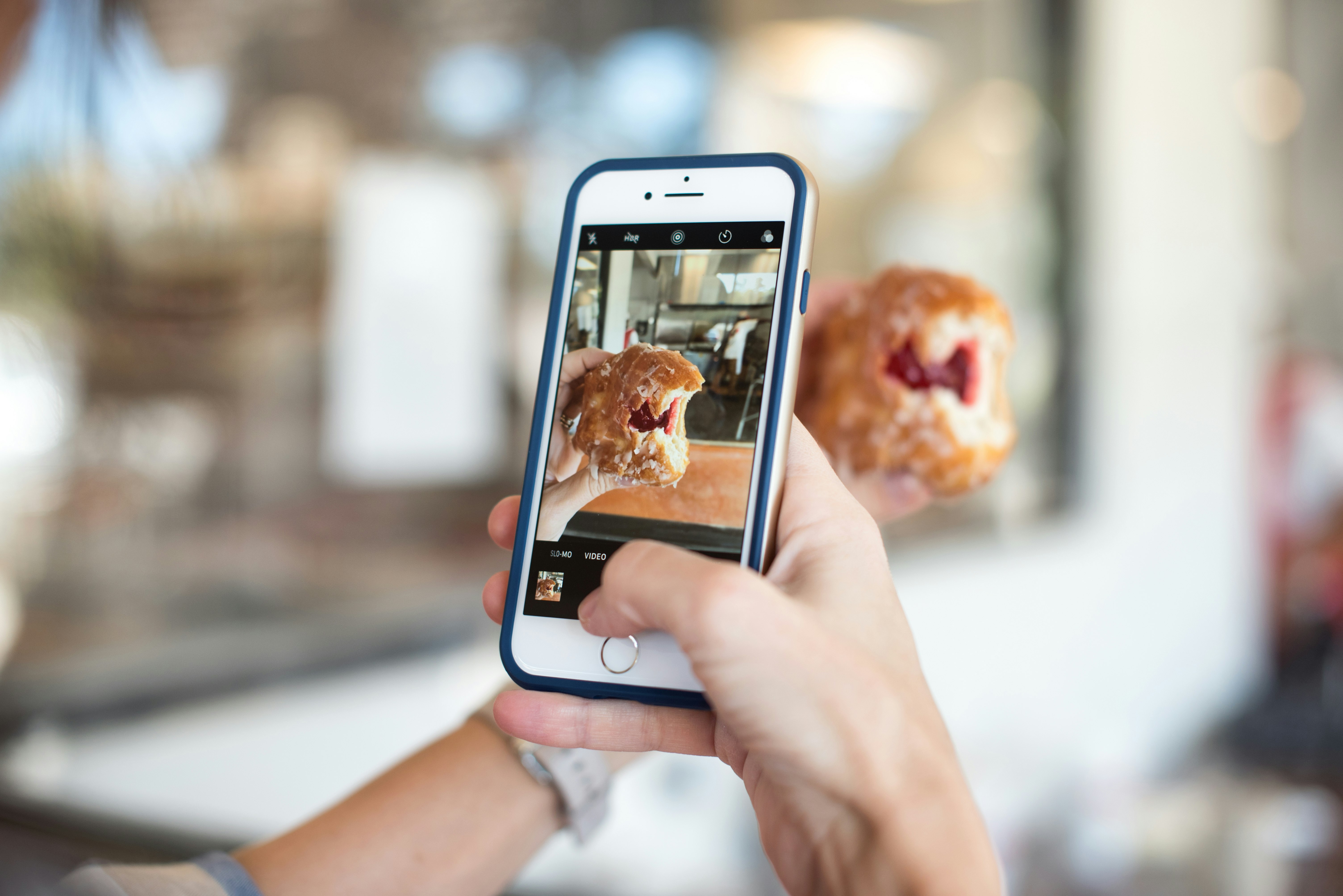 selective focus photography of person taking picture of brown food